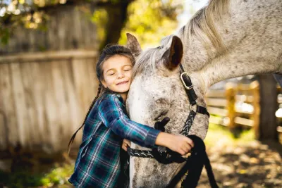 Niña abrazando caballo